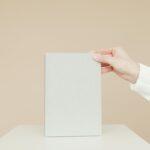 Simple minimalist image of a blank book being held by a person's hand, ideal for branding.