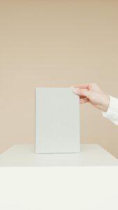 Simple minimalist image of a blank book being held by a person's hand, ideal for branding.