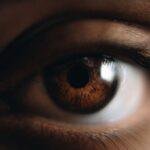 Detailed macro shot of a human eye with rich brown iris and natural lighting.