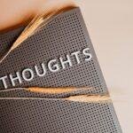 Close-up of a black perforated board with the word 'THOUGHTS' and wheat stalks.